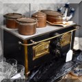 C11. Miniature stove with copper pots. 